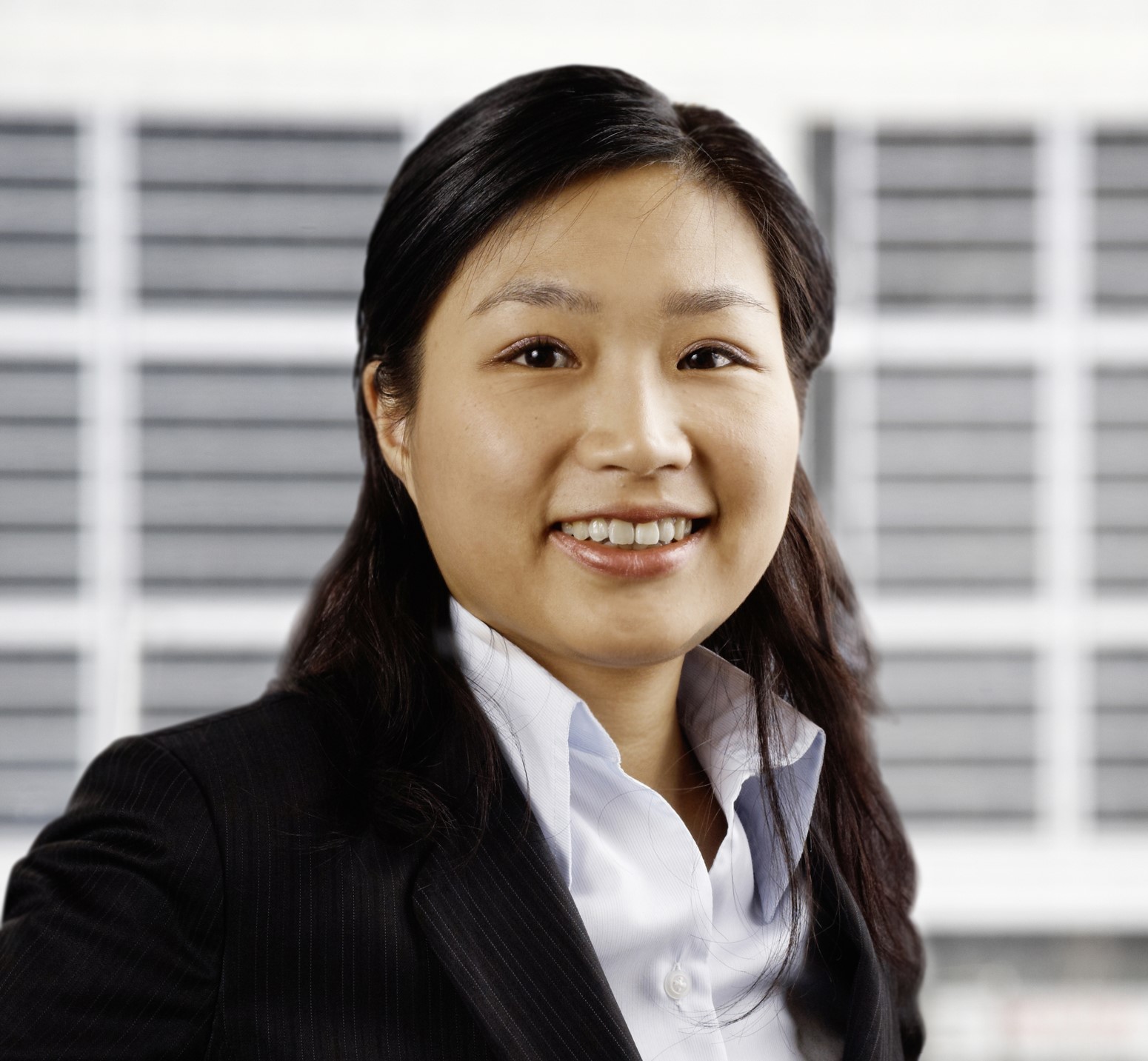 Professional headshot of a woman in a suit smiling confidently at the camera.